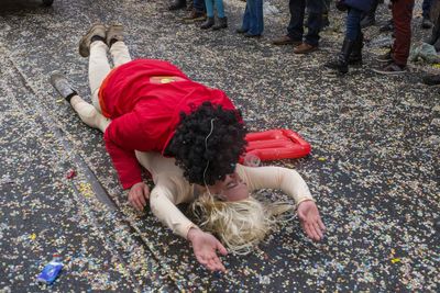 Man kissing woman while lying on road during carnival