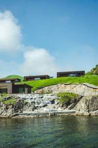 Houses by sea against sky