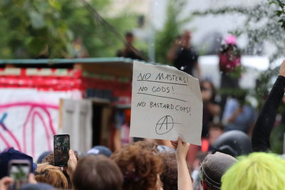 Rear view of people on smart phone during protest 