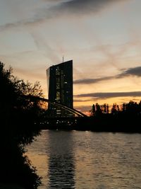 Bridge over river in city against sky