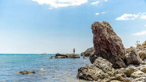 Rock formation in sea against sky