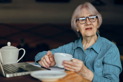 Portrait of young woman having coffee at home
