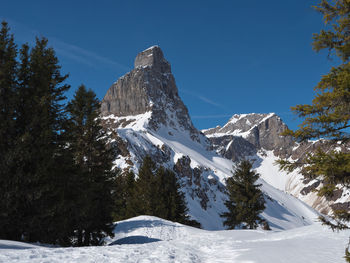 Scenic view of snowcapped mountains against clear blue sky