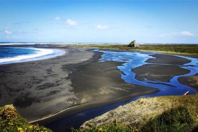 Scenic view of beach against blue sky