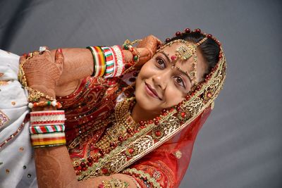 Close-up of smiling young bride against curtain