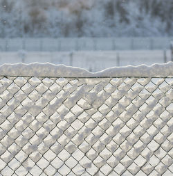 Close-up of snow covered chainlink fence