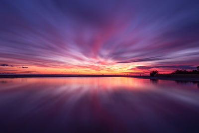 Scenic view of sea against dramatic sky during sunset