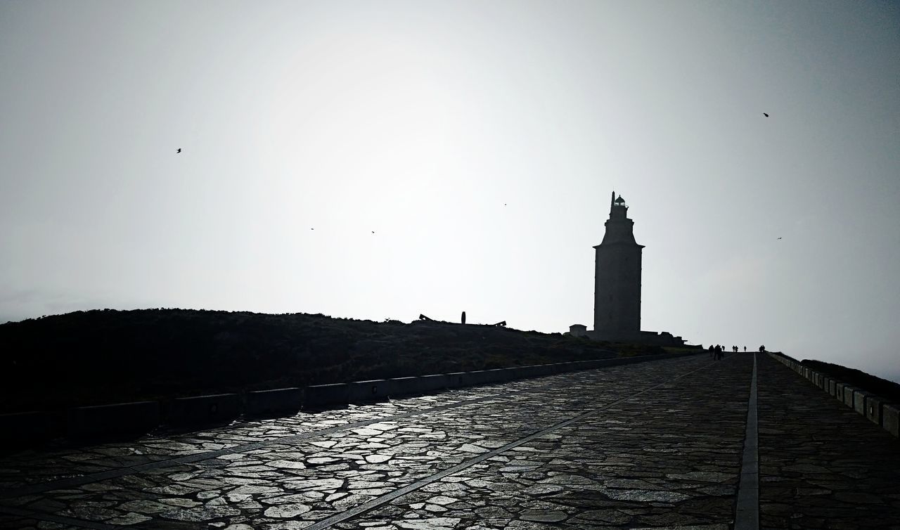 SILHOUETTE OF LIGHTHOUSE AGAINST BUILDING
