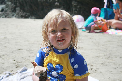 Portrait of cute girl on sand at beach