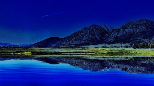 Reflection of mountain range in blue water