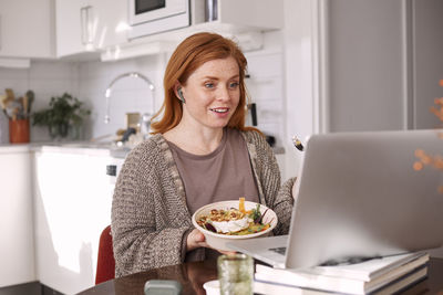 Smiling woman using laptop