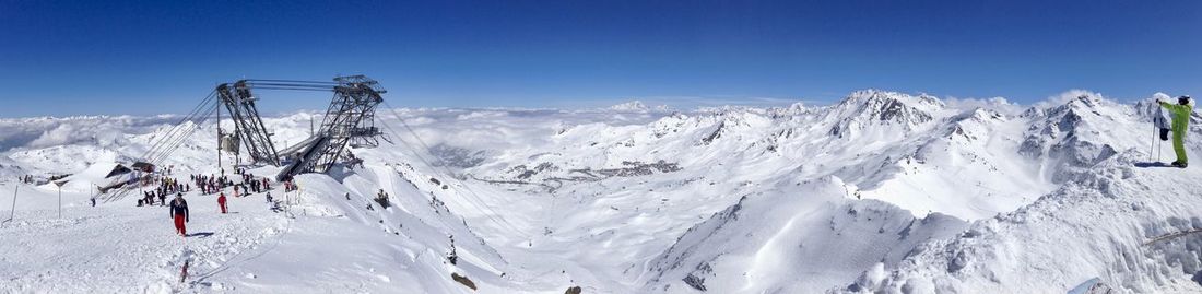 Scenic view of snowcapped mountains against blue sky