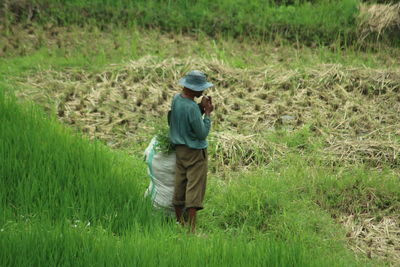 Rear view of man walking on field