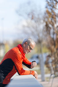 Side view of senior man looking at wristwatch