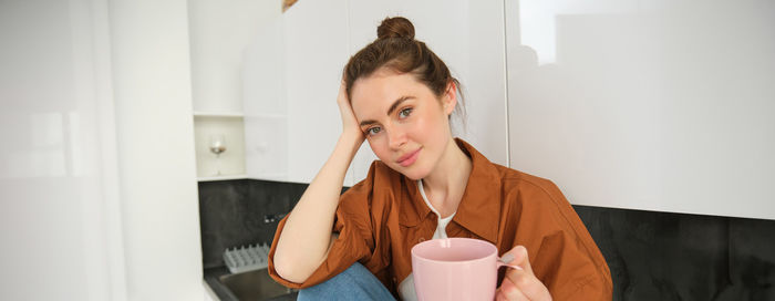 Young woman drinking coffee at home