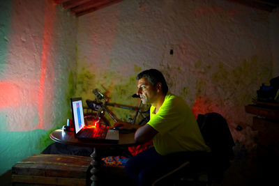 Man using laptop on table while sitting at home