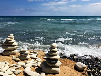 Stack of stones on beach against sky
