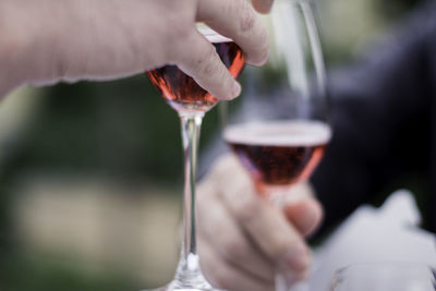 Midsection of person holding drink in glass