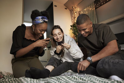 Smiling friends looking at photographs