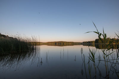 Scenic view of lake against sky at sunset