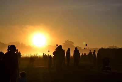 Silhouette people against sky during sunset