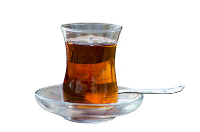 Close-up of tea in glass against white background