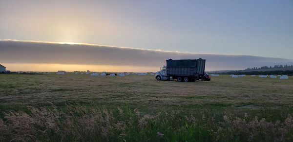 Lifeguard hut on field against sky during sunset