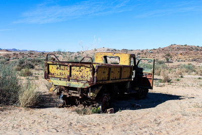 Abandoned truck on field against sky