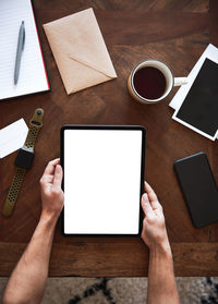 Low angle view of hand holding coffee cup on table