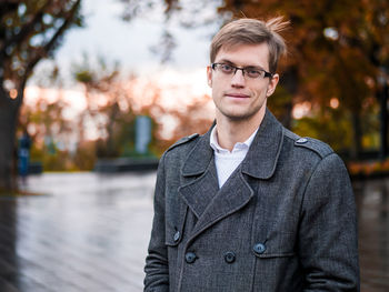 Portrait of businessman standing at park during autumn