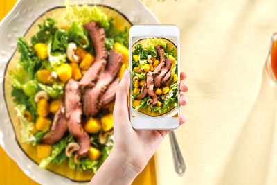 Close-up of hand holding salad