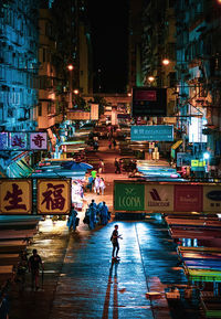 People walking on illuminated street at night