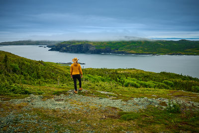 Rear view of woman walking on field