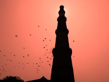 Low angle view of silhouette birds against sky at sunset