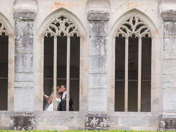 Full length of a man holding woman standing against building