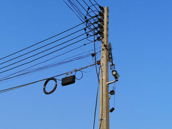 Low angle view of electricity pylon against sky