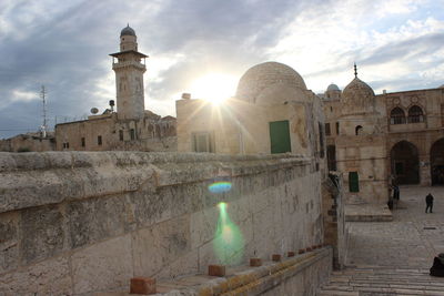 View of sunlight on historical building against sky