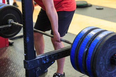 Mid section of a man exercising with barbell