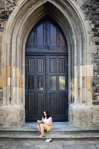 Woman sitting outside building