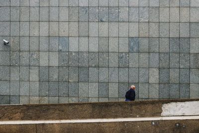 Senior man walking on staircase against wall