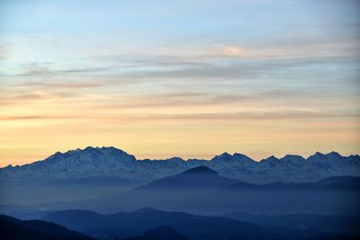 Scenic view of snowcapped mountains against sky during sunset