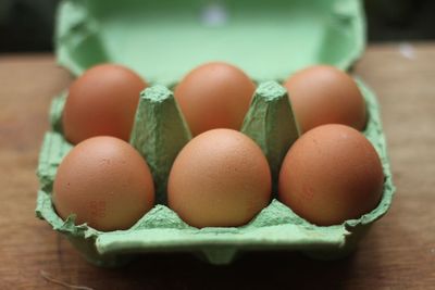 Close-up of brown eggs in crate on table