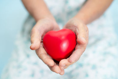 Midsection of woman holding heart shape