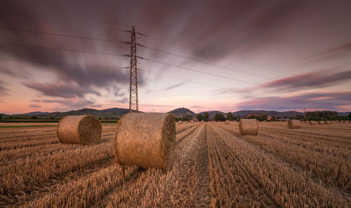 Hay bales on field against sky