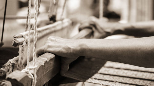 Cropped hands working in handloom