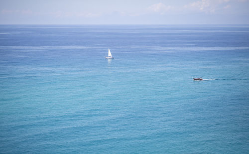 Sailboat sailing in sea against sky