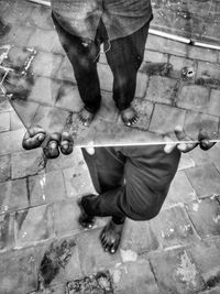 Low section of men standing on puddle