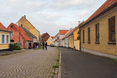 Street amidst buildings in town against sky