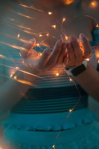 Midsection of person holding illuminated light
