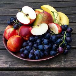 High angle view of fruits in plate on wooden table